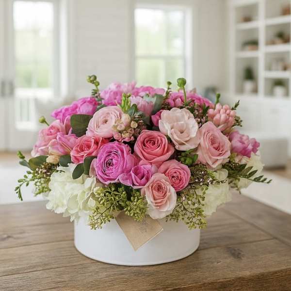 Pink and white rose arrangement in a white hat box