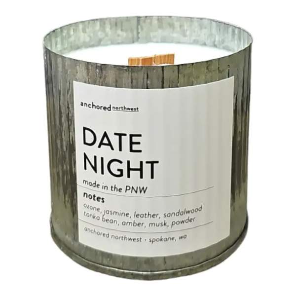 A scented candle in a rustic metal tin with a printed label