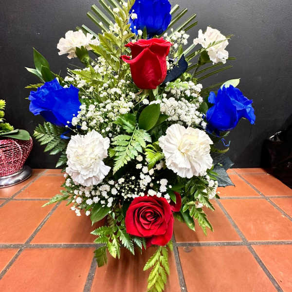 Red, blue, and white rose and carnation event arrangement in a fan-shaped design