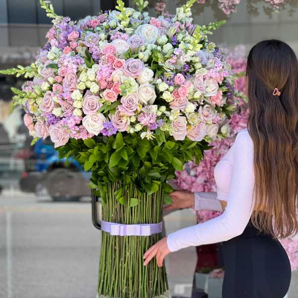 Large bouquet of pink and white roses with purple accents