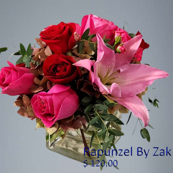 Pink and red roses with a pink lily in a glass vase