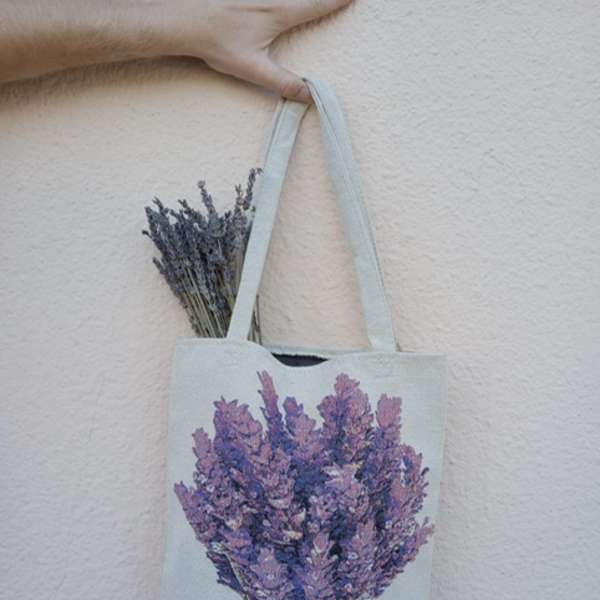 Canvas tote bag with a lavender bouquet print and dried lavender stems peeking out