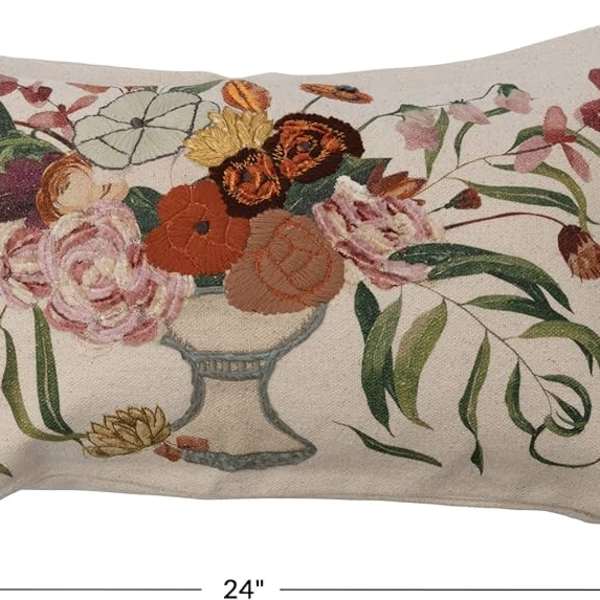 Floral embroidered pillow with a vase of mixed blooms