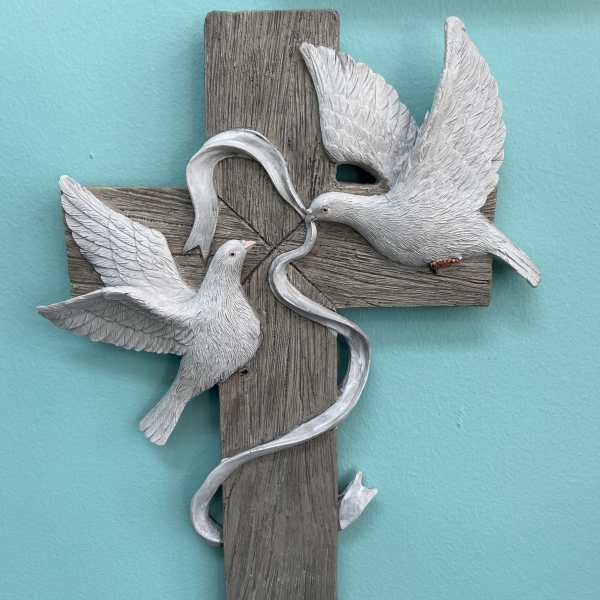 Wood-look cross wall plaque with two white doves and a flowing ribbon on a teal background