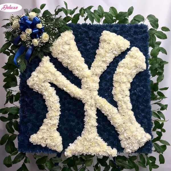 Blue floral tribute with white letter design and a small rose cluster