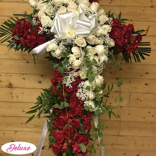 Cross-shaped floral tribute with white roses and red carnations
