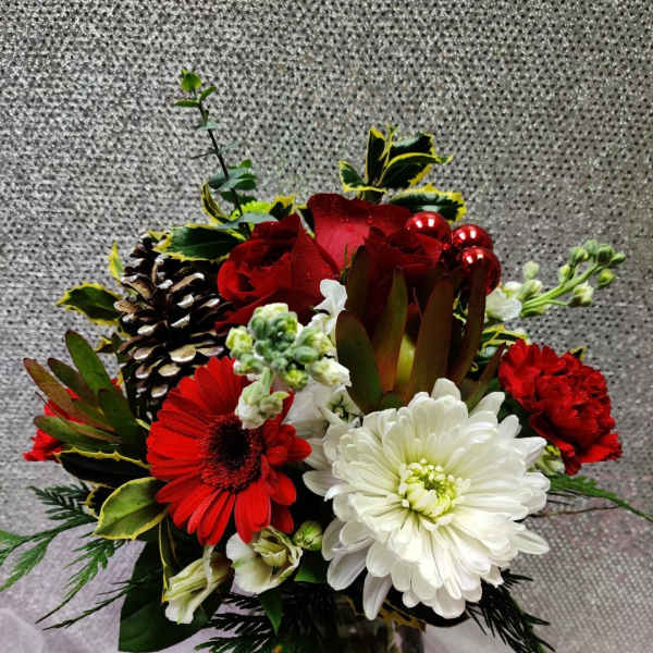 Red and white mixed flower arrangement in a glass vase
