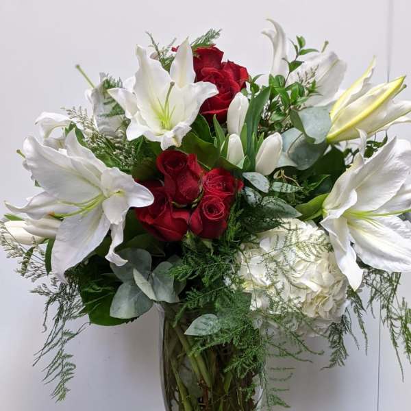 Red roses and white lilies in a clear glass vase