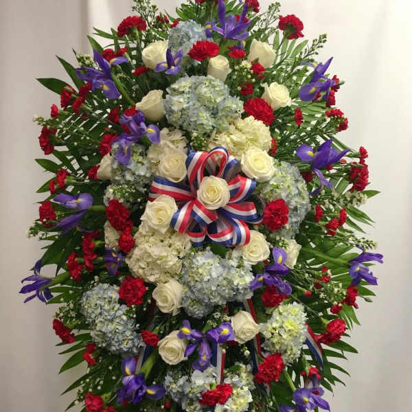 Large standing floral wreath with roses, hydrangeas, and purple irises