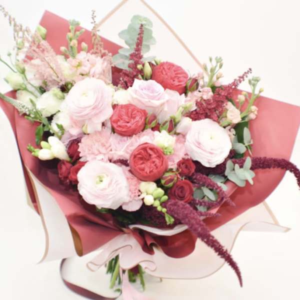 Pink and white mixed bouquet wrapped in burgundy paper