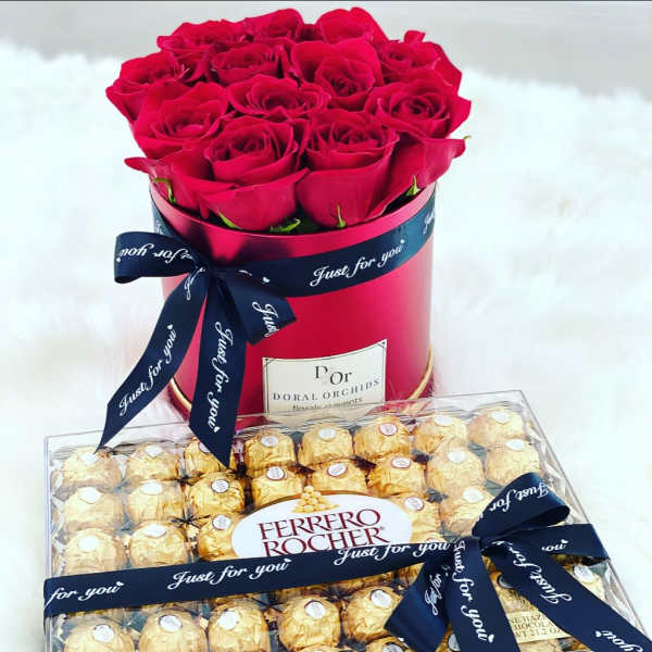 Red roses in a round box with a box of Ferrero Rocher chocolates