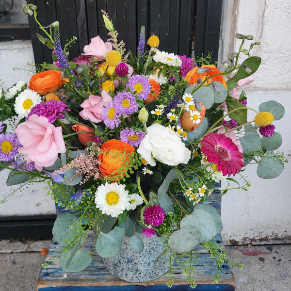 Colorful mixed bouquet in a speckled ceramic vase