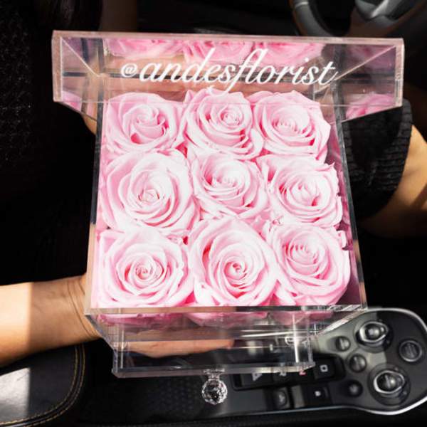 Pink roses arranged in a clear acrylic box