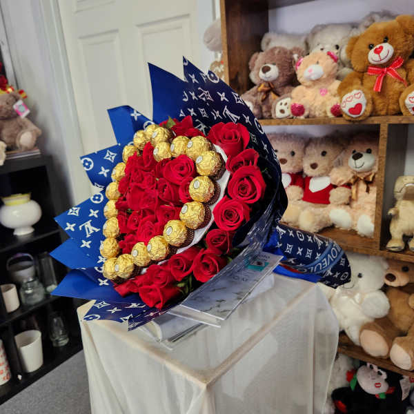 Bouquet of red roses with gold-wrapped chocolates in blue paper