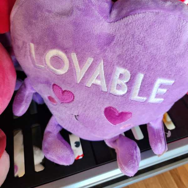 Purple heart-shaped plush with the word LOVABLE and small heart details