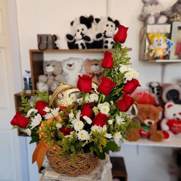 Basket arrangement of red roses and white daisies with an orange ribbon