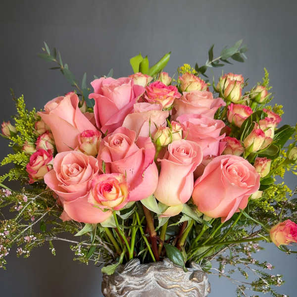 Pink roses arranged in a sculpted head vase