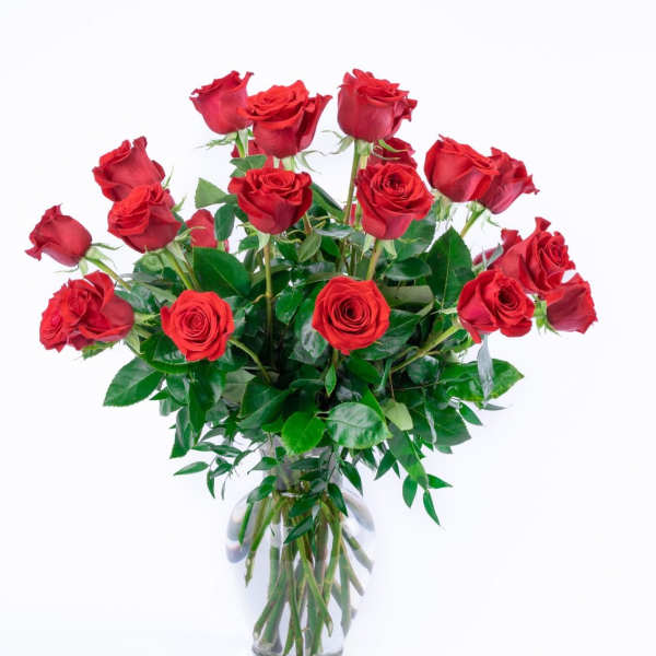 Tall bouquet of long-stemmed red roses in a clear glass vase
