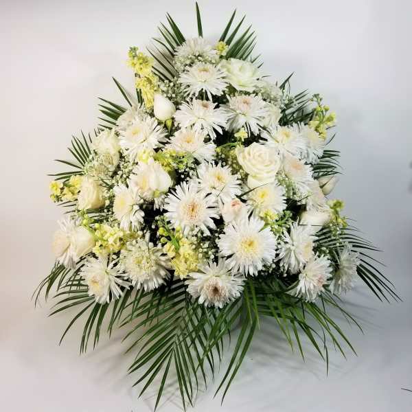 White floral spray with daisies and roses accented by palm fronds