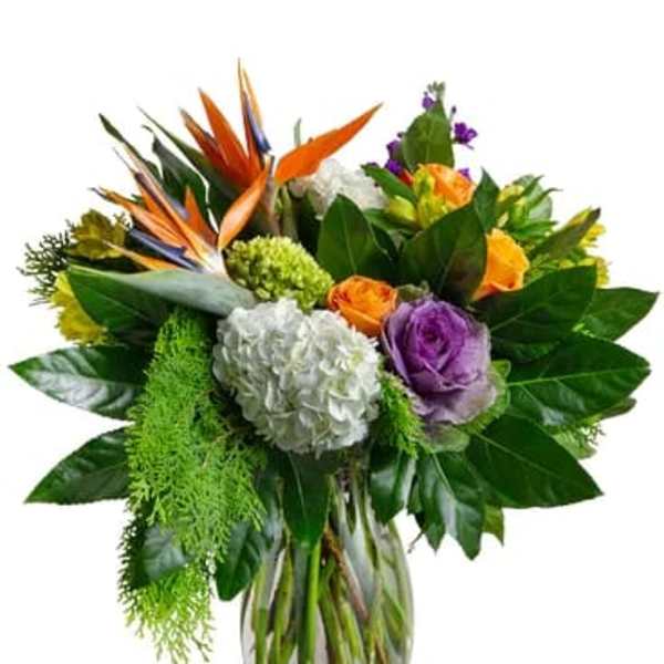 Mixed bouquet with orange and purple flowers in a glass vase