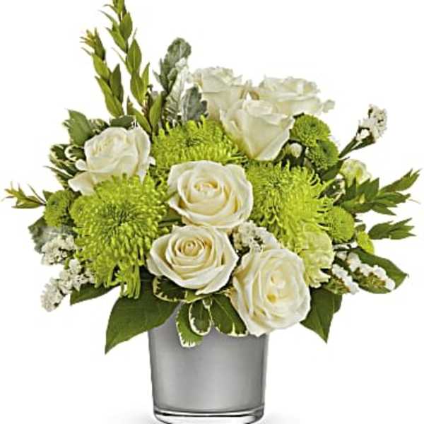 White roses and green mums arranged in a clear glass vase