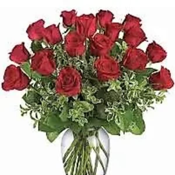 Arrangement of red roses with foliage in a clear glass vase