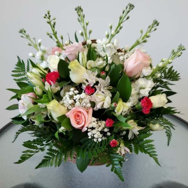 Mixed bouquet of pink and white flowers in a basket