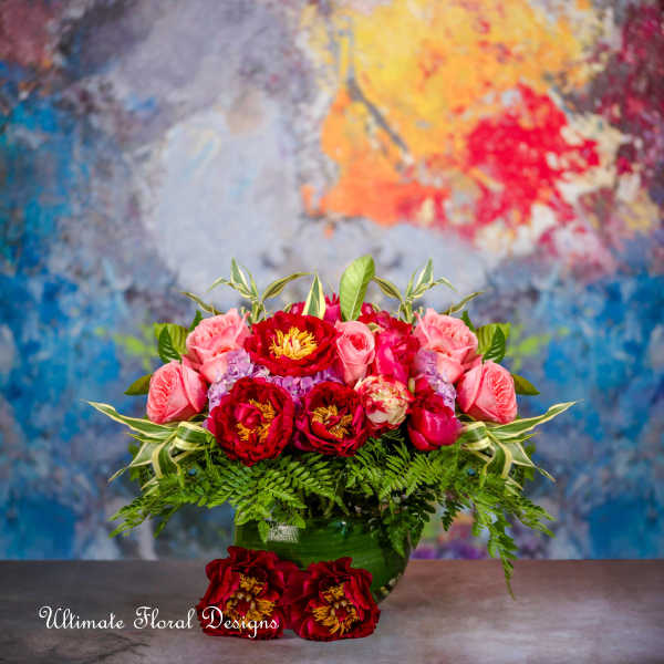 Pink and red flower arrangement in a green vase