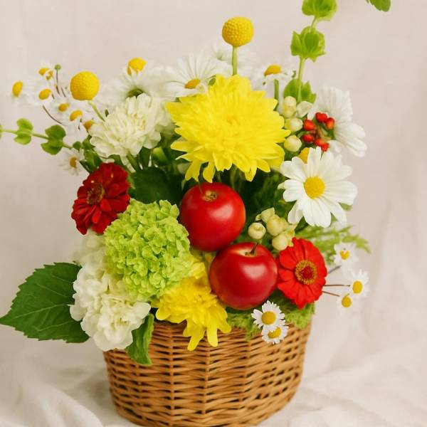 Basket arrangement with red apples and mixed flowers in yellow, white, red, and green