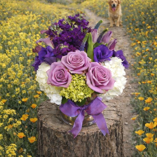 Purple and pink bouquet in a silver vase with a ribbon
