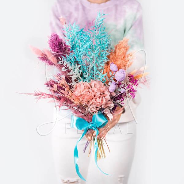 Colorful bouquet with pastel dried flowers tied with a blue ribbon