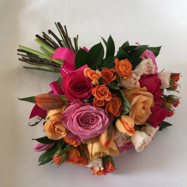Colorful bouquet of roses and tulips with a pink ribbon