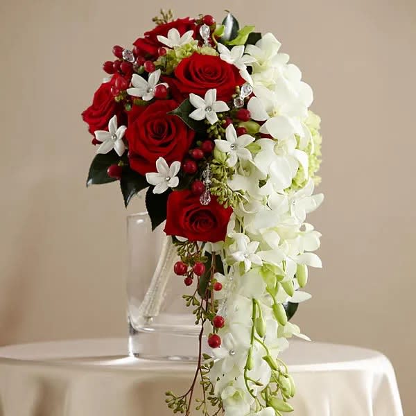 Red roses and white orchids arranged in a clear vase