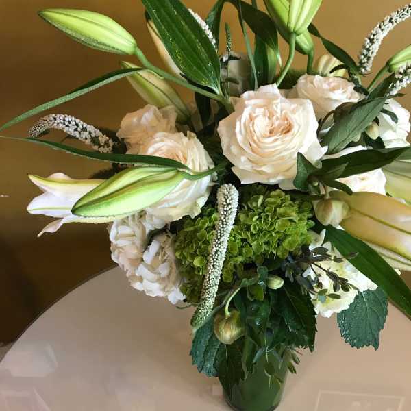 White roses and lilies arranged in a glass vase