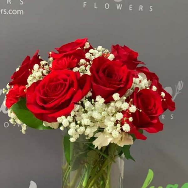 Red roses and white baby's breath in a clear glass vase