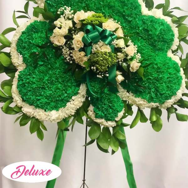 Large green and white floral standing spray with a ribbon bow