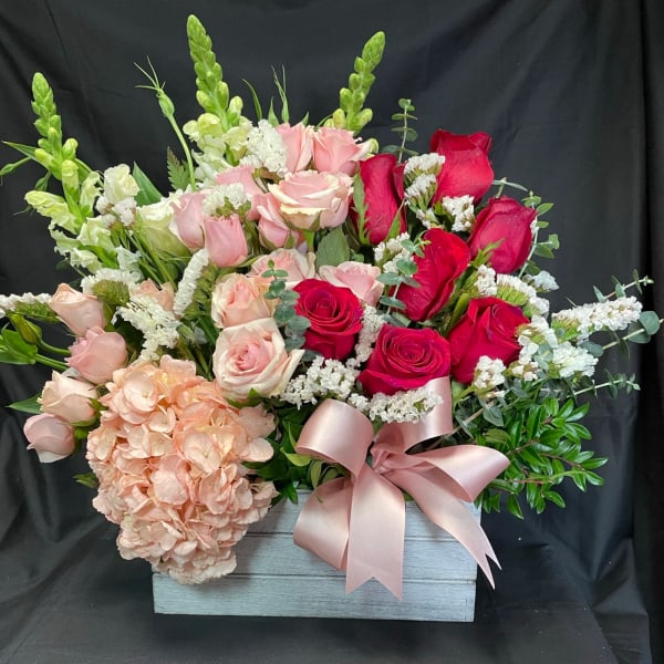 Pink and red roses with hydrangea in a wooden box