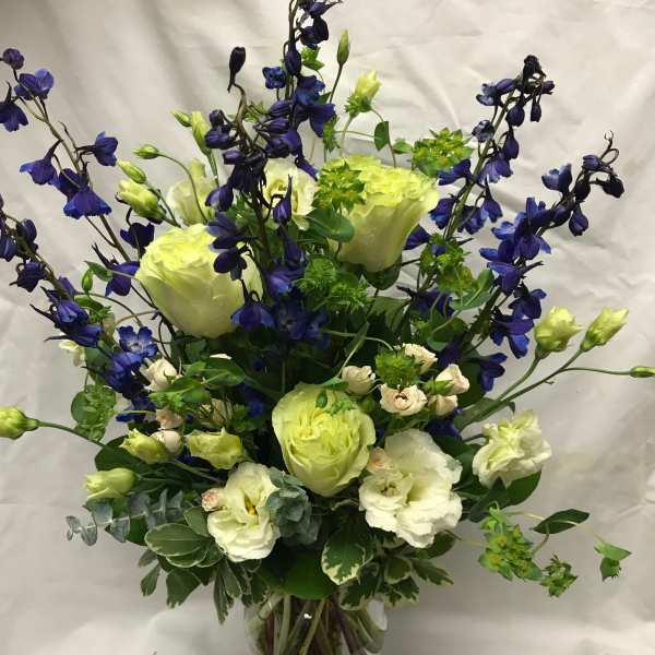 Blue and white floral arrangement in a clear glass vase