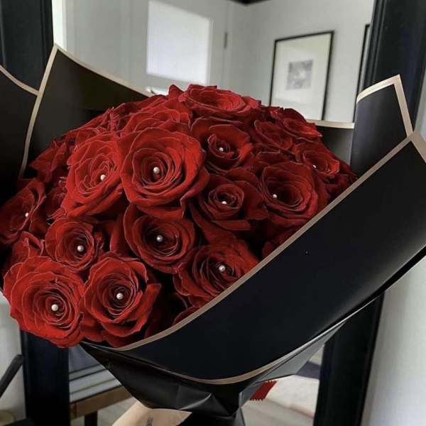 Bouquet of red roses wrapped in black paper