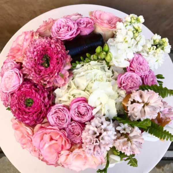 Round bouquet of pink and white flowers on a white surface