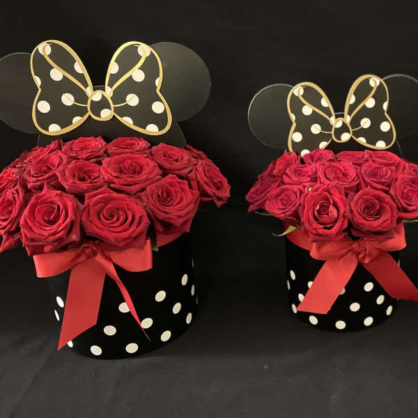 Three red rose arrangements in black polka-dot boxes with bow toppers