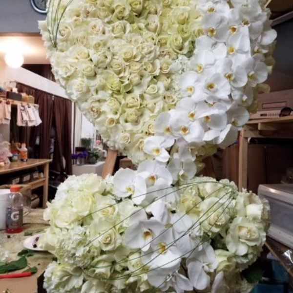Large white floral heart arrangement with roses and orchids