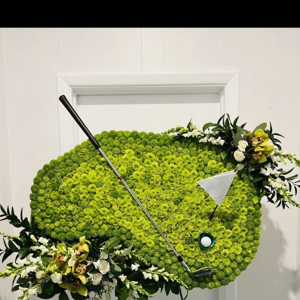 Golf-themed floral display with a golf club and ball on an easel