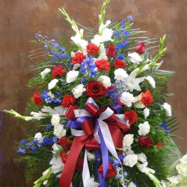 Standing floral spray with red, white, and blue flowers and ribbon