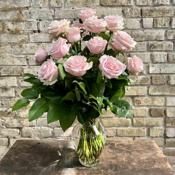 Pink roses arranged in a clear glass vase