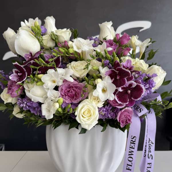 Lavender and white mixed bouquet in a white vase with ribbon