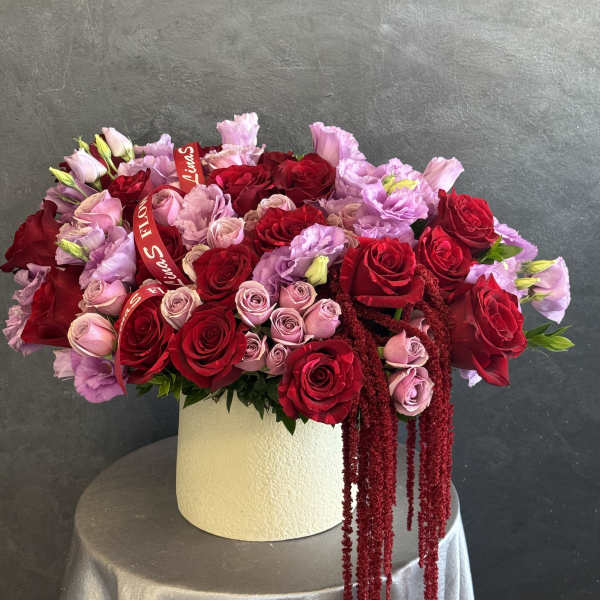 Large bouquet of red and pink roses in a white hat box