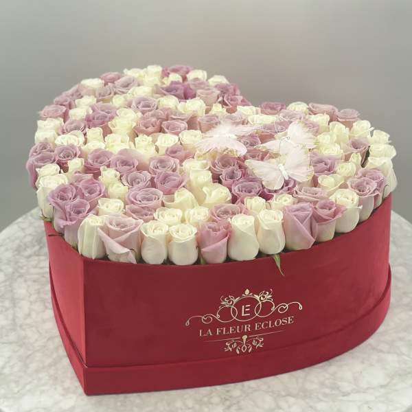 Heart-shaped box of pink and white roses with butterfly accents
