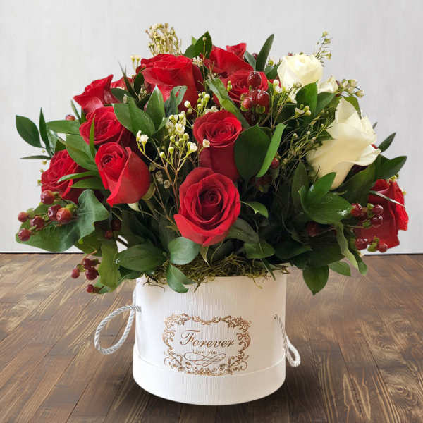 Red and white roses arranged in a white hat box