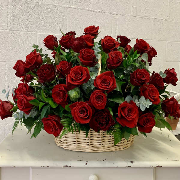 Basket of red roses with greenery